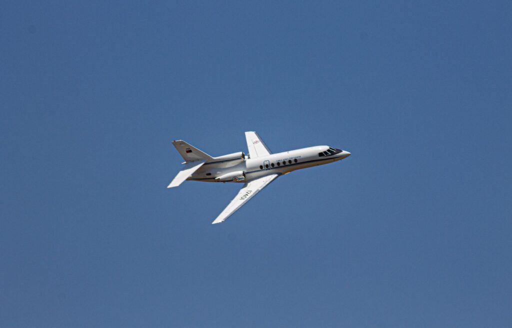 Private business jet flying through a clear blue sky